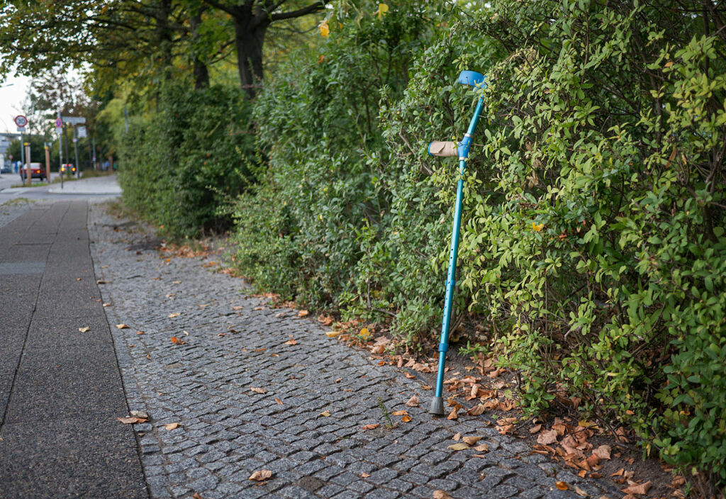 Berlin - Gehilfe lehnt an einer Hecke