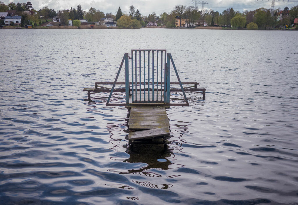 Nur das Tor eines Steges schwimmt auf dem See