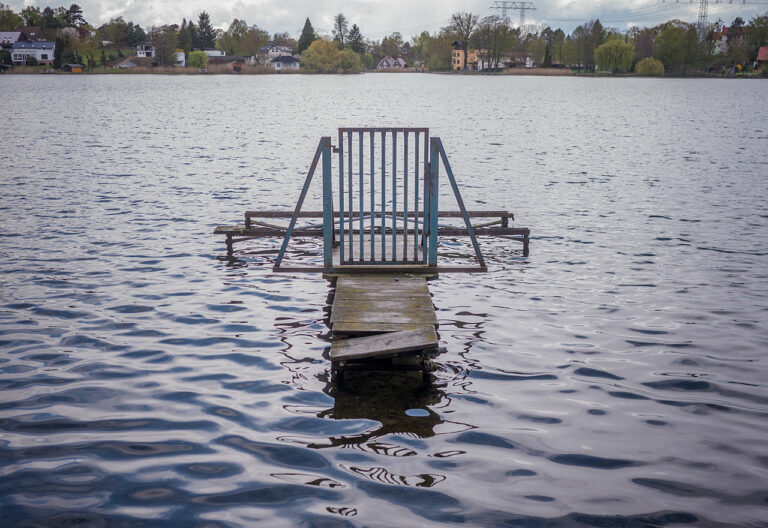 Nur das Tor eines Steges schwimmt auf dem See