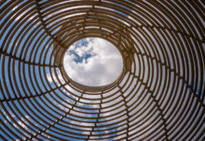 Durch eine geflochtene Spirale ist ein Wolkenhimmel zu sehen
