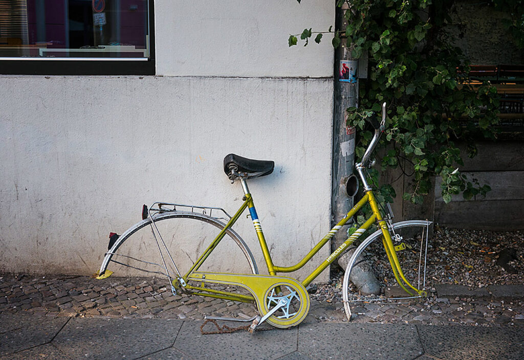 Ein Fahrrad ohne Räder lehnt an einer Hauswand