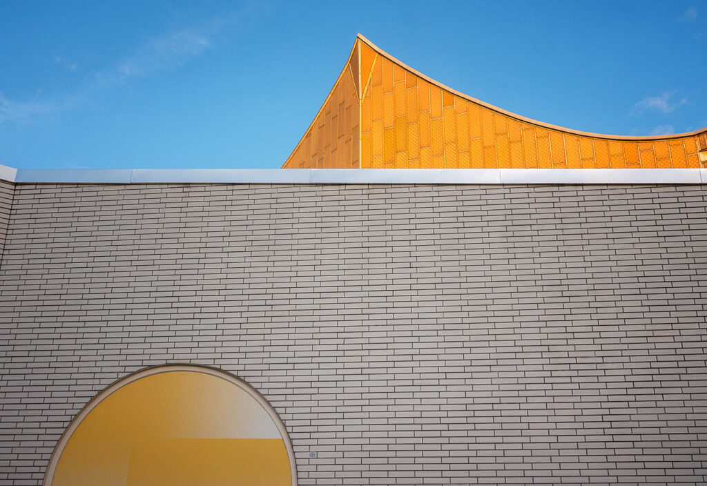 Ein Giebel der Philharmonie vor strahlend blauem Himmel