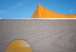 Ein Giebel der Philharmonie vor strahlend blauem Himmel