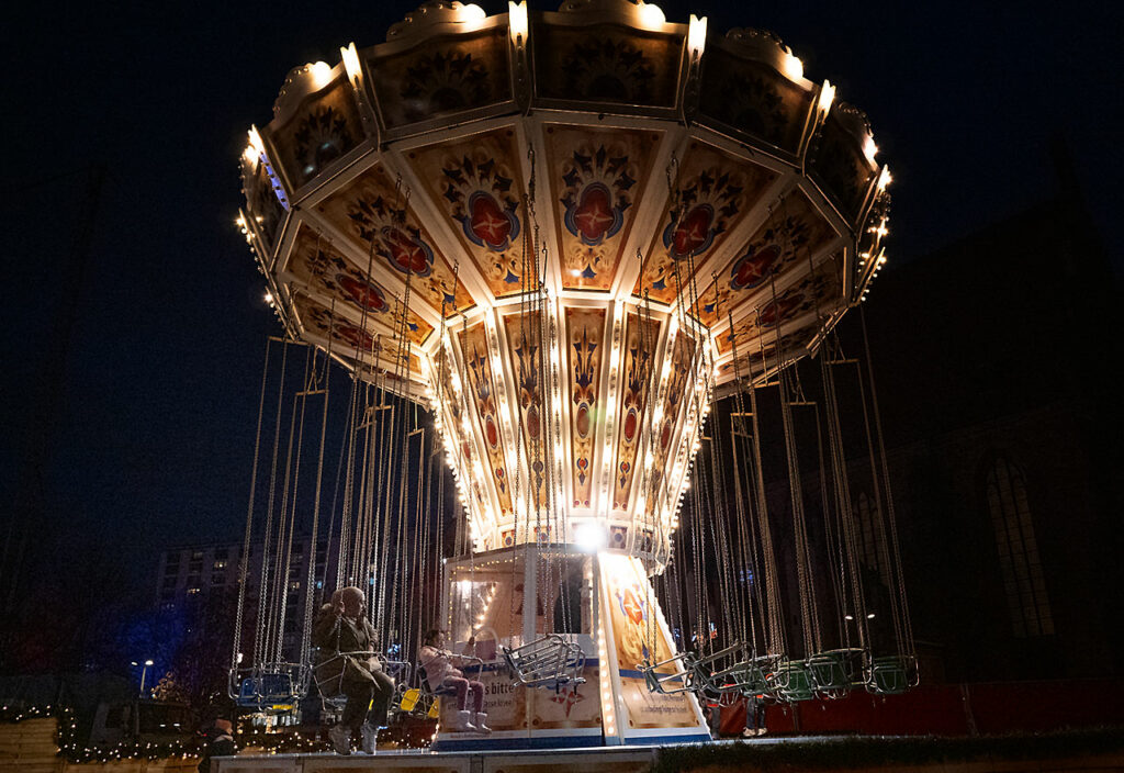 Ein Kettenkarussel auf dem Weihnachtsmarkt leuchtet schön in der Dunkelheit